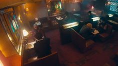 people sitting at tables in a dimly lit restaurant