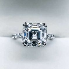 an emerald cut diamond ring with diamonds around it