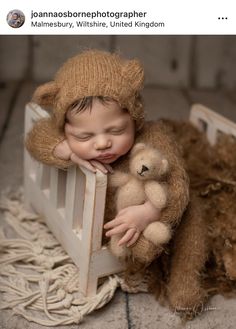 a baby is sleeping in a small chair with a teddy bear