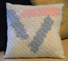 a crocheted pillow sitting on top of a couch