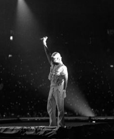 a man standing on top of a stage with his arm in the air while wearing an astronaut's helmet