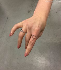 a person's hand with a small tattoo on it