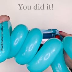 a person holding a blue balloon in front of a white wall with the words you did it