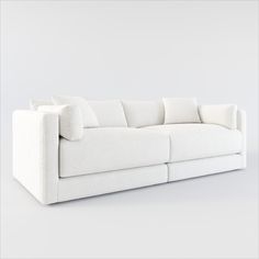 a white couch with pillows sitting on top of it