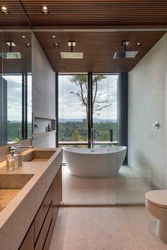 a bathroom with a large bathtub next to a toilet and sink under a window