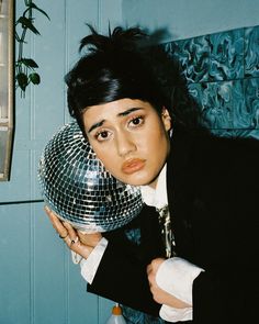 a woman holding a disco ball in front of her face