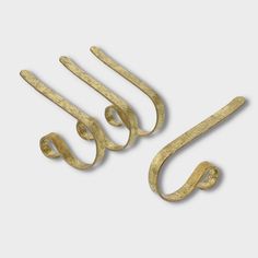 three gold metal hooks on a white background