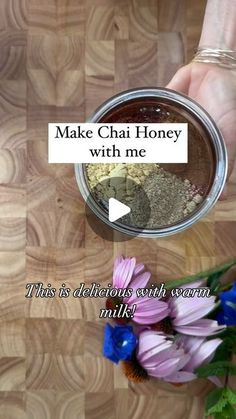 a person holding a jar with flowers in it and the words make chai honey with me