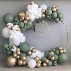 the balloon arch is decorated with gold, white and green balloons