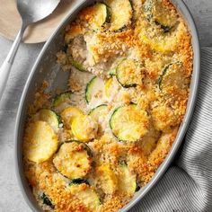 a casserole dish with zucchini and chicken in it on a table