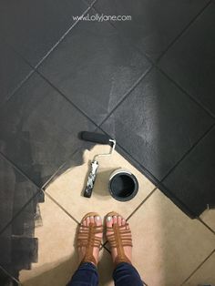 a person standing on a tiled floor with their feet propped up in front of them