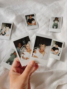 a person holding up four polaroid photos in front of them on a white blanket