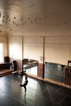 a young boy is practicing his moves in an empty room with mirrors on the wall