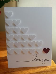 a white card with hearts and the word love you written on it