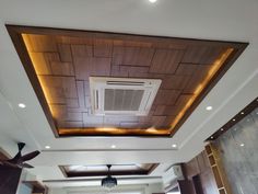 a living room filled with furniture and a ceiling mounted air conditioner on top of a wooden paneled ceiling