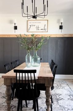 a dining room table with chairs and vases on it