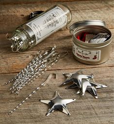 three silver stars are sitting next to a jar of tinsel and some other items