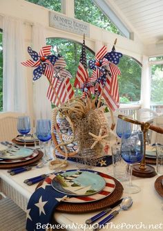 an american flag centerpiece on a dining room table set for fourth of july celebration