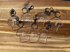 six keychains with numbers on them sitting on a wooden surface