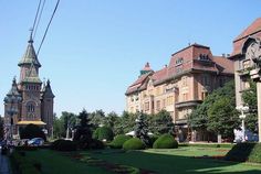 a large building with a clock tower in the middle of it's garden area