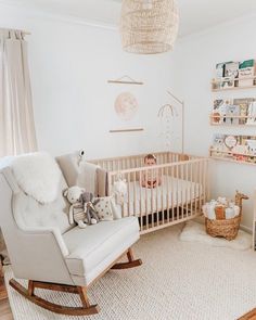 a baby's room with a rocking chair, crib and bookshelf