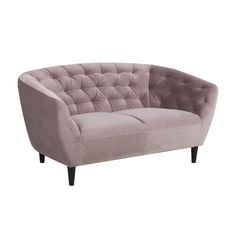 a pink velvet sofa with black legs and buttons on the back, in front of a white background