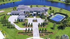 an aerial view of a large house with a tennis court in the middle of it