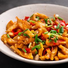 a white bowl filled with food on top of a black table next to a fork