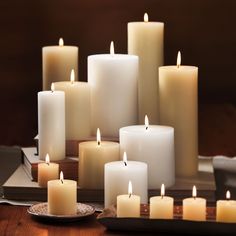 many lit candles are arranged on a table