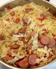 sausage and cabbage cooking in a pan on top of the stove with other food items