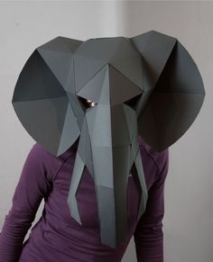 the woman is wearing an elephant's head made out of grey or black paper