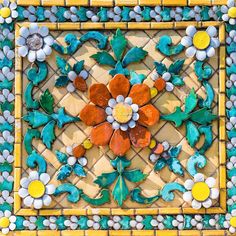 an artistic tile work with flowers and leaves