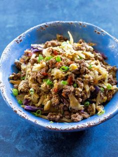 a blue bowl filled with meat and vegetables