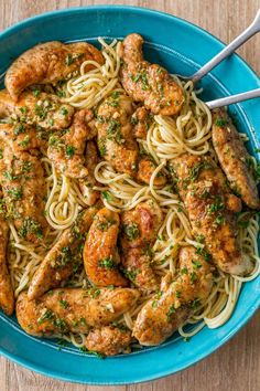 a blue bowl filled with pasta and meat