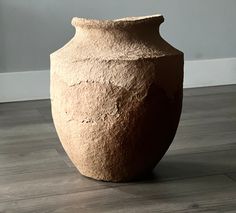 a large vase sitting on top of a hard wood floor