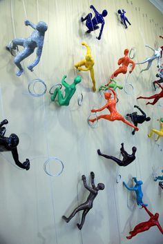 many different colored figurines are hanging on the wall