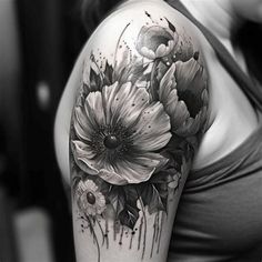 a woman's arm with flowers and watercolors on the back of it