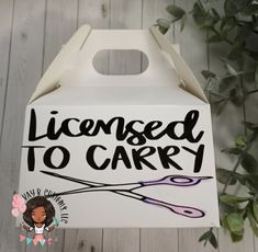 a white box with the words license to carry printed on it and a pair of scissors