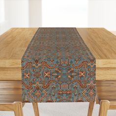 a wooden table topped with a blue and red rug on top of a wooden table