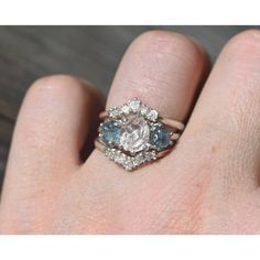 a woman's hand with a diamond and blue topaz ring on her finger