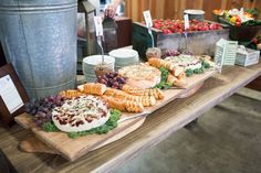 a wooden table topped with lots of different types of foods and desserts on top of it