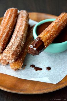 two sugar coated donuts on a plate with dipping sauce