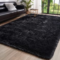 a living room with a black couch and rug