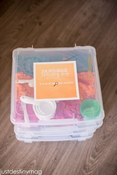 a plastic container filled with lots of different colored sand