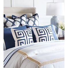 a bed with blue and white pillows on it