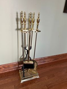 a metal candelabra with five candles on it's stand in front of a wall