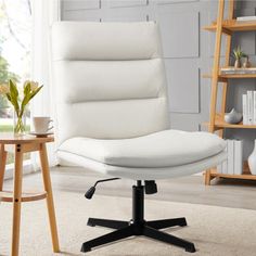 a white office chair sitting on top of a carpeted floor next to a wooden table