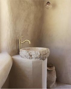 a white sink sitting next to a bath tub in a bathroom under a light fixture