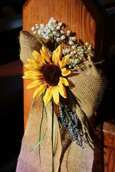 a sunflower and some baby's breath flowers are on the back of a chair