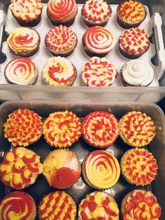 there are many cupcakes in the box and one is red, yellow and white